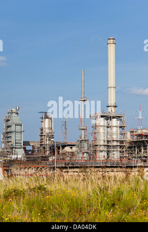 Destillation-Türme und Rohre in einer Raffinerie tagsüber mit grünen Vordergrund. Stockfoto