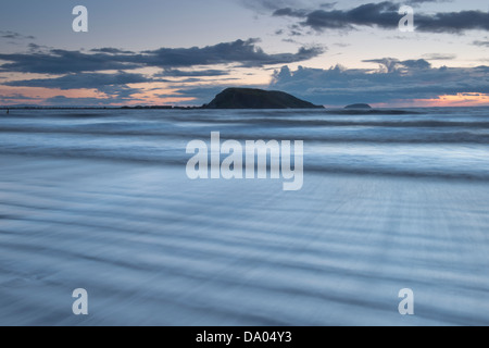 Sonnenuntergang über bergauf Strand mit Brean unten am Horizont sichtbar. North Somerset, UK. Stockfoto