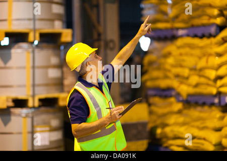 mittleren Alter Versand Unternehmen Arbeitnehmer zählen Paletten im Lager vor dem Versand Stockfoto