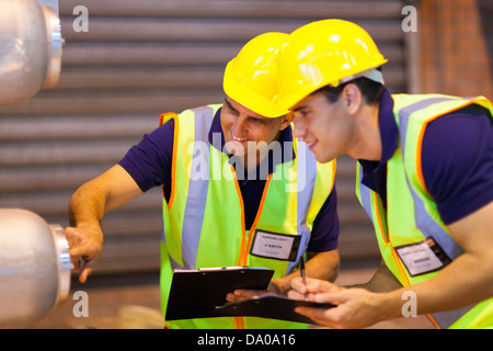 Lagermitarbeiter in Sicherheit Zahnrad kontrollierenden Maschinen Stockfoto