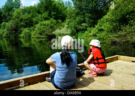 Asiatische Mädchen Mutter BC Fischerei Gesellschaft Binnenfischerei in Stadt Dock Learn Fisch Programm Heiligtum Teich Vancouver Stockfoto