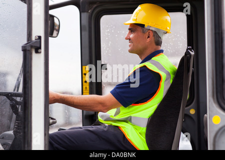 mittleren Alter professionelle Lagerarbeiter Stapler in Betrieb Stockfoto