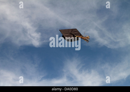 Graduation Cap bei einer Abschlussfeier vor blauem Himmel mit weißen Wolken, erfolgreich freien Flug durch die Luft fliegen! Stockfoto