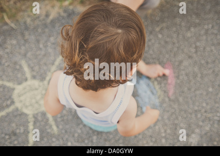 Kleiner Junge spielt mit Kreiden Stockfoto