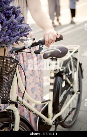 Frauen halten Retro-Bike mit Lavendelblüten Stockfoto