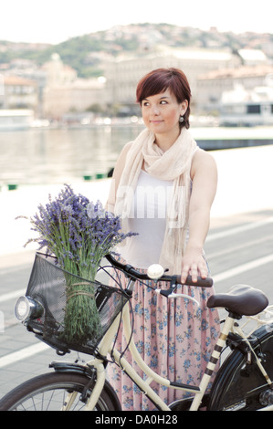 Frauen mit Retro-Bike mit Lavendelblüten in Korb Stockfoto