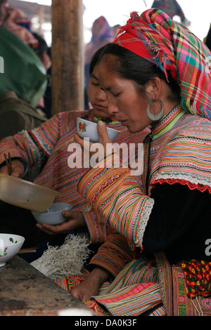 Flower Hmong Frauen traditionelle Stammes-Essen und trinken Tee auf dem Markt in Bac Ha, Vietnam, Südostasien Stockfoto