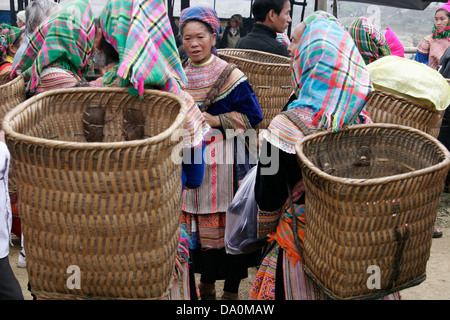 Flower Hmong Frauen tragen riesige geflochtene Körben auf dem Tier Markt in Bac Ha, Vietnam, Südostasien Stockfoto