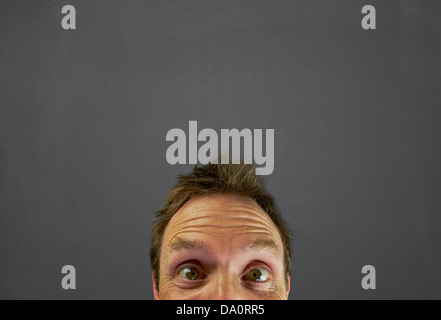 Mans Kopf vor einer Tafel mit einer Leerstelle schreiben oder zeichnen eine Nachricht oben. Stockfoto