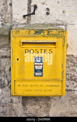 Ein typische gelbe Französisch La Poste Briefkasten montiert auf einer Steinmauer in Langais, Frankreich Stockfoto