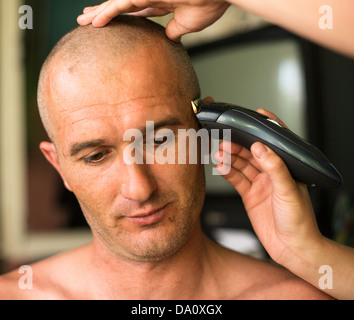 Nahaufnahme: Friseur rasieren Mann mit Haarschneidegerät. Stockfoto