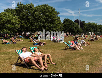 Menschen, die ein Sonnenbad im Hyde Park London UK am Sonntag 30. Juni Sommer 2013 Stockfoto