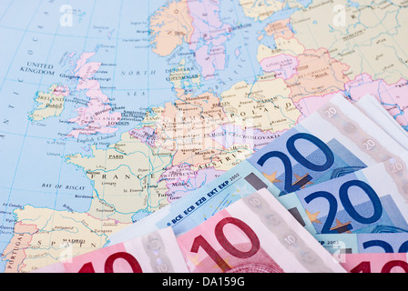 Euro-Banknoten auf einer Karte von Europa Stockfoto