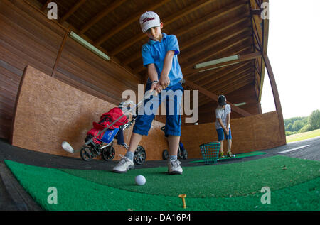 Ein kleiner Junge Praktiken zur Abschlag auf dem Golfplatz St. Leon-Rot, Deutschland, 19. Juni 2013. Die Badische Stadt St. Leon-Rot ist ein Zentrum für die Förderung junger Talente im Bereich der Golf. Foto: Uwe Anspach Stockfoto