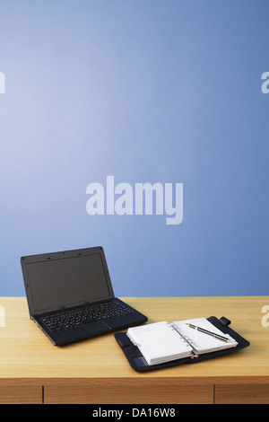 Agenda auf hölzernen Schreibtisch und Laptop Stockfoto