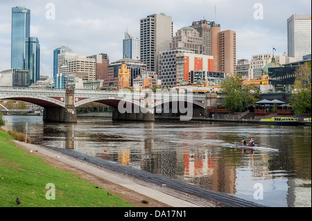 Ruderer trainieren entlang des Yarra River in der Nähe der Princes Bridge in zentraler Geschäft Bezirk von Melbourne, Australien. Stockfoto