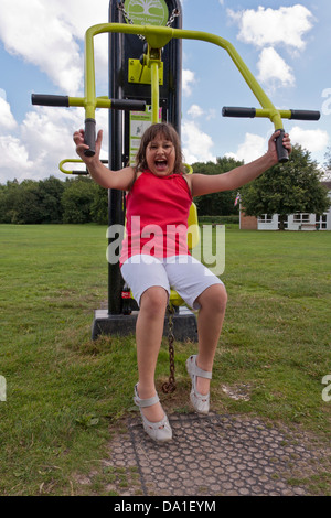Kind Training zu einem Outdoor-Gymnasium in einem öffentlichen Park im Süden Englands. Stockfoto