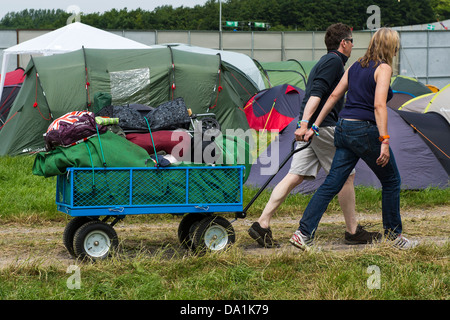 Ankünfte - die Sonne verblasst bald und der Regen beginnt. Die Leute bringen alles von Bier bis. Die 2013 Glastonbury Stockfoto