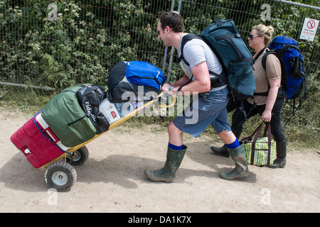 Ankünfte - die Sonne verblasst bald und der Regen beginnt. Die Leute bringen alles von Bier bis. Die 2013 Glastonbury Stockfoto