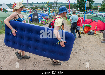 Anreise - die Sonne bald verblasst und der Regen beginnt. Menschen bringen alles aber um dort zu helfen ist auch ein Inflate Sie Dienst Bett Stockfoto