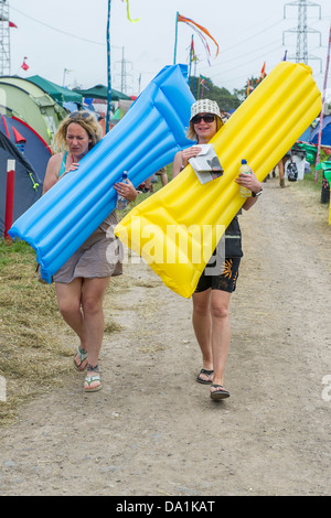 Anreise - die Sonne bald verblasst und der Regen beginnt. Menschen bringen alles aber um dort zu helfen ist auch ein Inflate Sie Dienst Bett Stockfoto