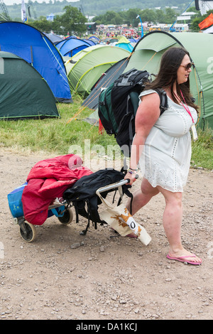 Ankünfte - die Sonne verblasst bald und der Regen beginnt. Die Leute bringen alles von Bier bis. Die 2013 Glastonbury Stockfoto