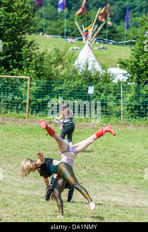 Erwachsene und Kinder spielen und entspannen um den Steinkreis, während um sie herum die Müllsammler ihre unendliche Arbeit fortsetzen Stockfoto