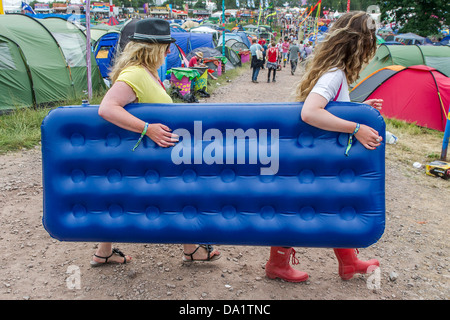 Anreise - die Sonne bald verblasst und der Regen beginnt. Menschen bringen alles aber um dort zu helfen ist auch ein Inflate Sie Dienst Bett Stockfoto