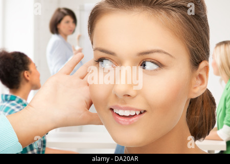 Schüler Mädchen hören Klatsch in der Schule Stockfoto