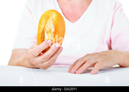 Ältere weibliche Hände halten eine Brot Stockfoto