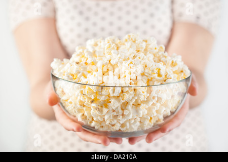 Mädchen schwarze Punkte T-shirt Betrieb Glas Schüssel popcorn Stockfoto