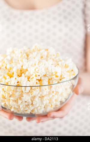 Mädchen am schwarzen Punkte T-shirt hält eine Glasschüssel popcorn Stockfoto