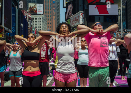 Tausende von Yoga-Praktizierende packen Times Square in New York Stockfoto