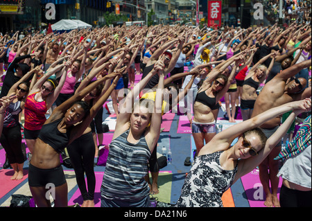 Tausende von Yoga-Praktizierende packen Times Square in New York Stockfoto