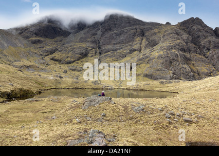 Einsame Gestalt vom Ufer des Loch Fionna Chor mit Blaven in der Black Cuillin Berge, Isle Of Skye, Schottland Stockfoto