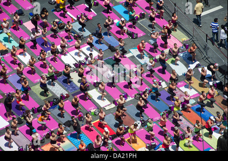 Tausende von Yoga-Praktizierende packen Times Square in New York Stockfoto