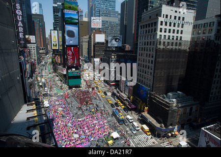 Tausende von Yoga-Praktizierende packen Times Square in New York Stockfoto