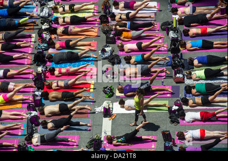 Tausende von Yoga-Praktizierende packen Times Square in New York Stockfoto