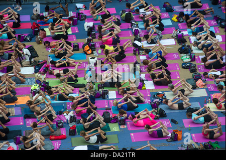 Tausende von Yoga-Praktizierende packen Times Square in New York Stockfoto