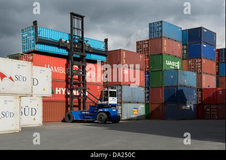 Ein lifting Fahrzeug hebt einen Container aus einem Stapel von anderen in Trafford Park in der Nähe von Manchester (nur zur redaktionellen Verwendung). Stockfoto