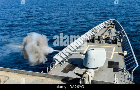 U.S. Navy geführte Flugkörper Kreuzer USS Monterey feuert seine MK-45 5-Zoll, Kaliber.54-leichte Gewehr während einer live-Feuer-Übung 27. Juni 2013 in das Arabische Meer. Stockfoto