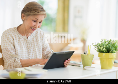 Ältere Frau mit Tablet-pc zu Hause Stockfoto