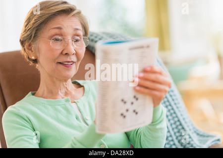 Ältere Frau macht Kreuzworträtsel Stockfoto