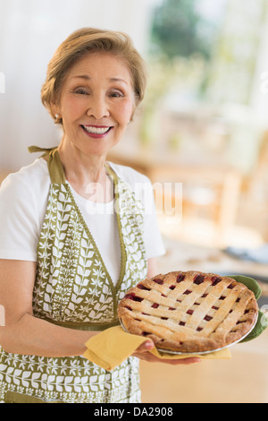 Ältere Frau mit frisch gebackenem Kuchen Stockfoto
