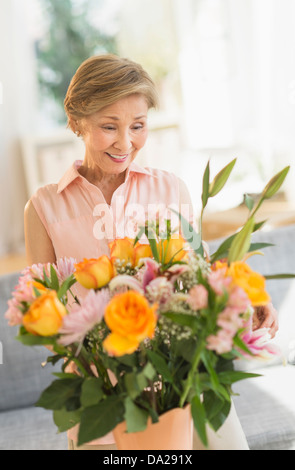 Ältere Frau arrangieren von Blumen zu Hause Stockfoto