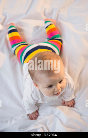 Porträt des Mädchens (6-11 Monate) auf Bett liegend Stockfoto