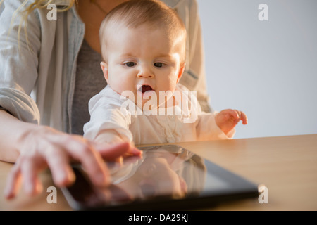 Mutter und Baby Tochter (6-11 Monate) spielen mit digital-Tablette Stockfoto