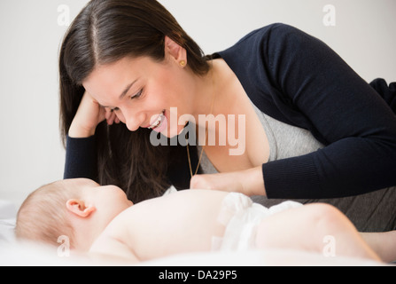 Porträt von Mutter und Baby Tochter (6-11 Monate) im Bett liegend Stockfoto