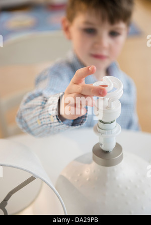 Jungen (4-5) berühren Energie effiziente Glühbirne Stockfoto