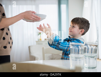 Mutter des jungen (4-5) helfen, Tisch Stockfoto